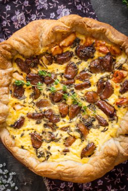 Koyu ahşap backgrou üzerinde keçi peyniri ile sarımsak tart karamelize