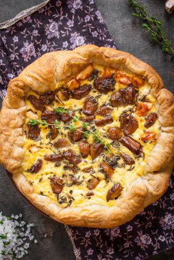 Koyu ahşap backgrou üzerinde keçi peyniri ile sarımsak tart karamelize