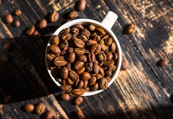 Tasse avec grains de café au soleil du matin — Photo