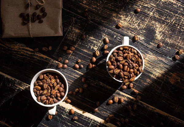 Tazze con chicchi di caffè alla luce del sole del mattino — Foto Stock