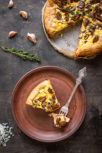 Tarta de ajo caramelizado con queso de cabra sobre fondo de madera oscura —  Fotos de Stock