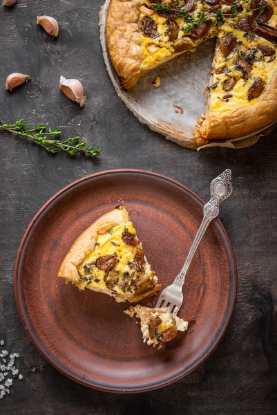 Карамелізований часниковий пиріг з козячим сиром на темному дерев'яному фоні — стокове фото