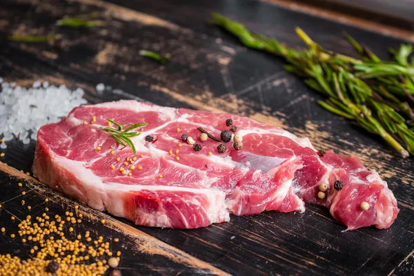 Bistecca di carne succosa cruda su fondo di legno scuro pronta per essere arrostita — Foto Stock