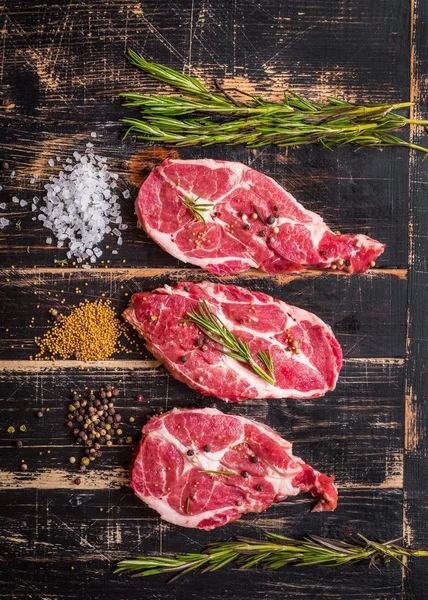 Nyers hús steak pörkölés készek, sötét fából készült háttér — Stock Fotó