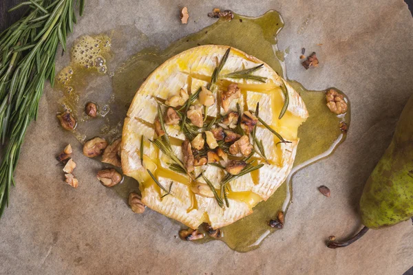 Delicious zapečený hermelín s medem, vlašskými ořechy, byliny a hrušky — Stock fotografie