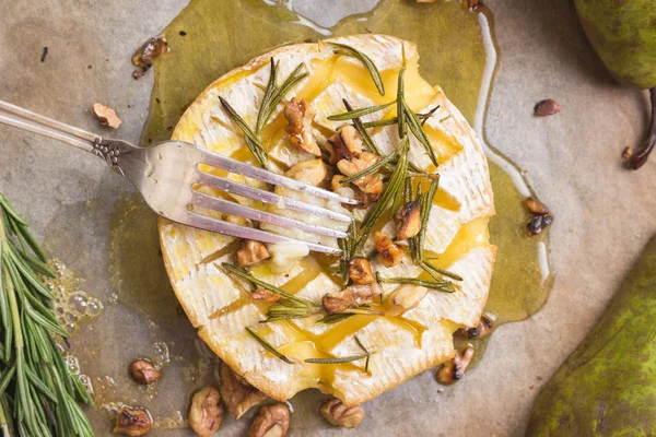 Délicieux camembert cuit au four au miel, noix, herbes et poires — Photo