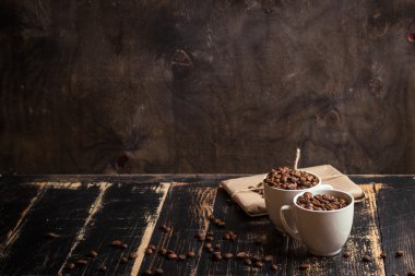 Fincan kahve çekirdekleri, koyu ahşap arka plan ile
