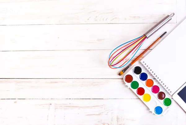 Sketch pad with paints, brush, whisk and tablet — Stock Photo, Image