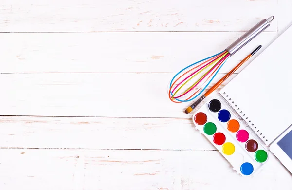 Sketch pad with paints, brush, whisk and tablet — Stock Photo, Image