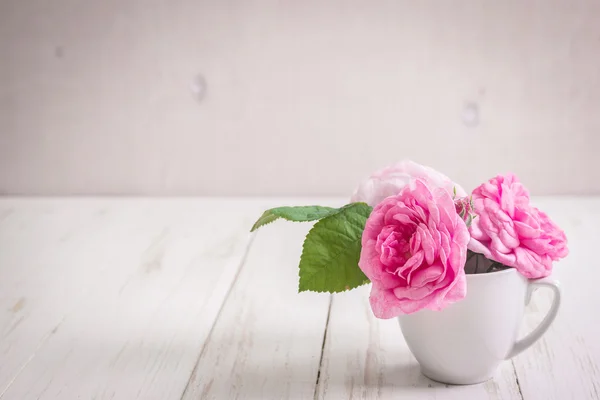 Roze rozen van de thee op een witte houten achtergrond — Stockfoto