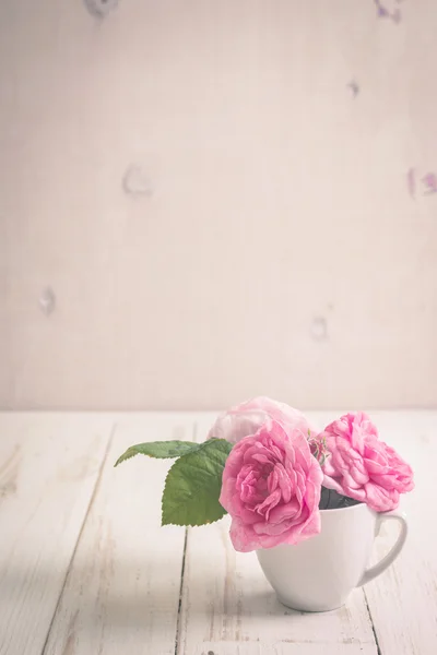 Rosas de té rosadas sobre un fondo de madera blanca — Foto de Stock