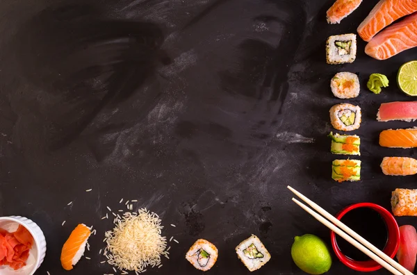 Sushi e ingredientes sobre fundo escuro — Fotografia de Stock