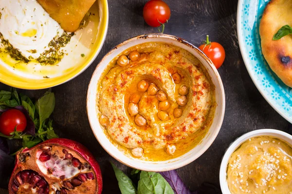 Mesa servida com pratos vegetarianos do Oriente Médio. Hummus, tahi. — Fotografia de Stock