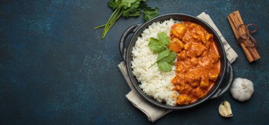 Kremalı domates soslu Hint tavuğu tikka masala. Basmati pilavı, taze kişniş ve baharatla servis ediliyor. Geleneksel Hint yemeği.