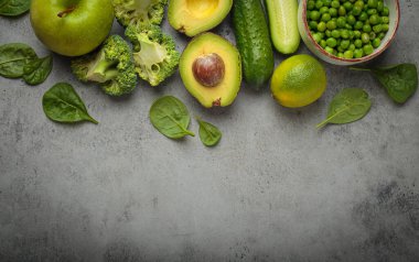Taze yeşil sebzeler ve meyve grisi beton arka plan üst görüş, diyet, vejetaryen. Farklı yeşil sağlıklı ürünler seti, metin için temiz yeme alanı