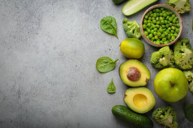 Taze yeşil sebzeler ve meyve grisi beton arka plan üst görüş, diyet, vejetaryen. Farklı yeşil sağlıklı ürünler seti, metin için temiz yeme alanı