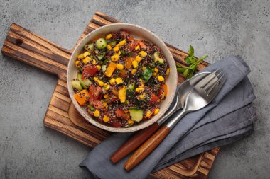 Siyah kinoalı kinoa salatası, taze domates, mısır ve salatalık sağlıklı vejetaryen ve vejetaryen yemeklerini temsil ediyor.