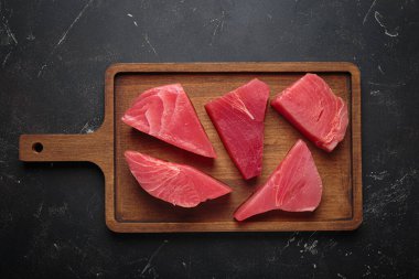 Taze kesilmiş ton balığı bifteği pişirmeye hazırlanıyor, tahtadan dilimler.