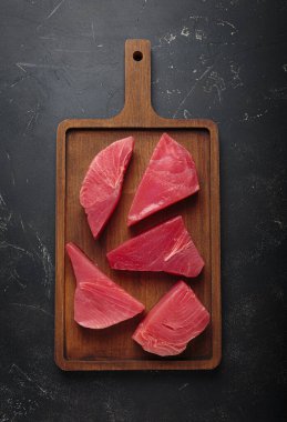 Taze kesilmiş ton balığı bifteği pişirmeye hazırlanıyor, tahtadan dilimler.