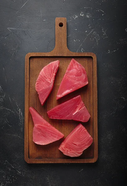 Taze kesilmiş ton balığı bifteği pişirmeye hazırlanıyor, tahtadan dilimler.