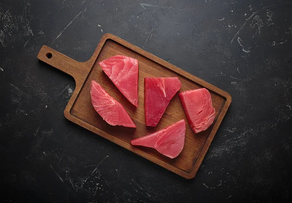 Taze kesilmiş ton balığı bifteği pişirmeye hazırlanıyor, tahtadan dilimler.