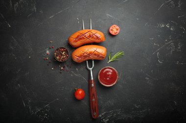 Izgara sosis ve biber, biberiye, vişneli domates ve ketçap karışımıyla servis edilir.