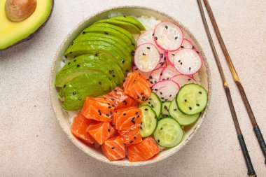 Poke kasesi, doğranmış çiğ somon, avokado, pirinç ve sebzelerle servis edilen sebzeli geleneksel Hawai yemeği, hafif arka planda sağlıklı bir yemek.