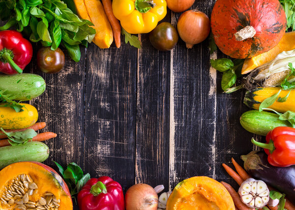 Fresh vegetables on a rustic dark textured table. Autumn backgro
