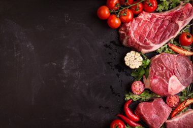 Çiğ et biftek kavurma için hazır karanlık bir arka plan üzerinde