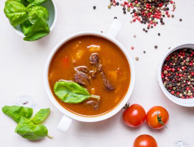 Beyaz ahşap backgrou üzerinde beyaz bir kase etli domates çorbası