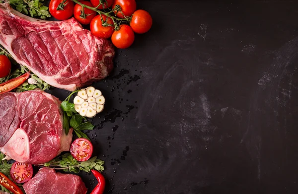 Rohe Fleischsteaks auf dunklem Hintergrund bereit zum Braten — Stockfoto