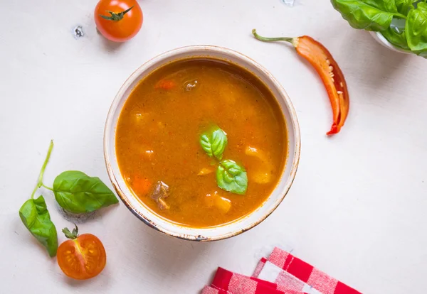 Tomatsoppa med kött i en vit skål på en vit trä ba — Stockfoto