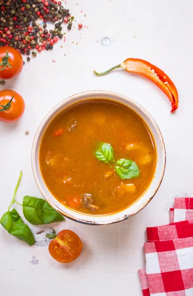 Tomatsoppa med kött i en vit skål på en vit trä ba — Stockfoto