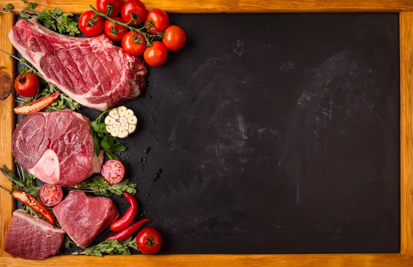 Filetes de carne cruda sobre un fondo oscuro listos para asar —  Fotos de Stock