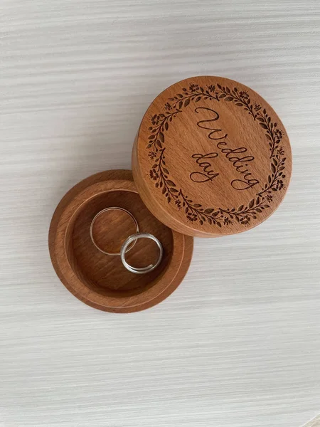 有结婚戒指的珠宝盒 带戒指的木盒刻有婚礼当天字样的木盒 免版税图库照片