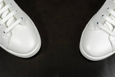 Siyah arka planda izole edilmiş beyaz spor ayakkabılar.