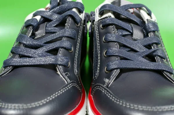 Yeşil Zeminde Izole Edilmiş Beyaz Tabanlı Siyah Spor Ayakkabılar — Stok fotoğraf