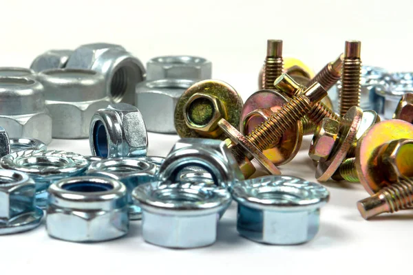 Sarı cıvatalar ve beyaz arka planda parlak fındıklar.