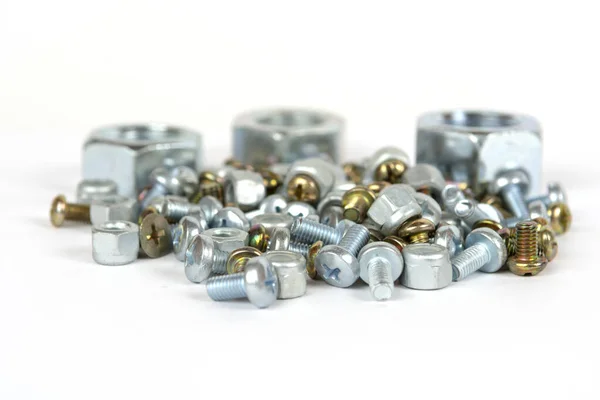 Bir grup küçük cıvata ve büyük metal fındık.