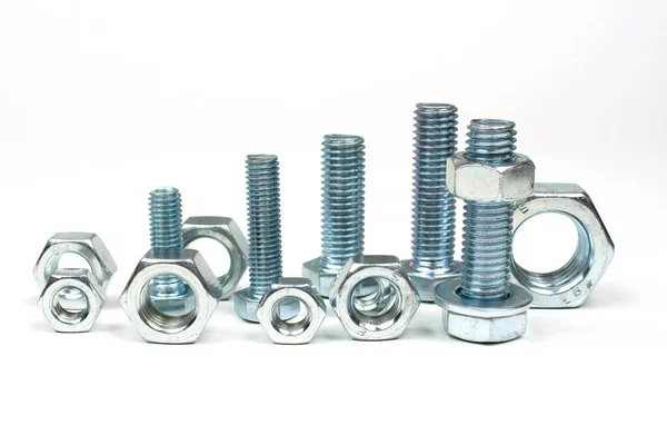 Metalden yapılmış birkaç somun ve cıvata. Beyaz arka planda uzun olmayan.