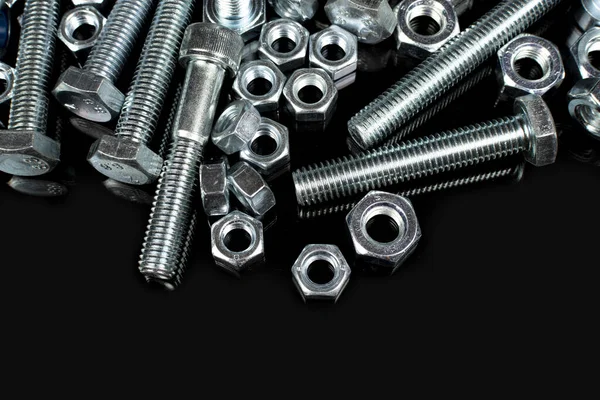 Metal civatalar ve fındıklar siyah arkaplanda kopyalama alanı ile