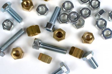 Beyaz arka planda metalden yapılmış cıvatalar ve fındıklar
