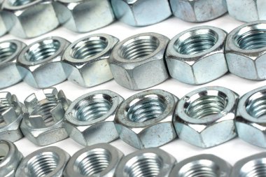 Beyaz arka planda farklı boyutlarda metal fındıklar