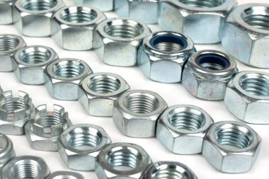 Beyaz arka planda farklı boyutlarda metal fındıklar