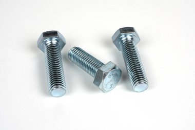 Beyaz arkaplanda üç cıvata metal.