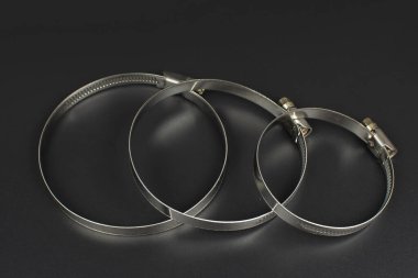 Hortum bağlantısı için çeşitli metal kıskaçlar siyah arkaplanda izole edildi