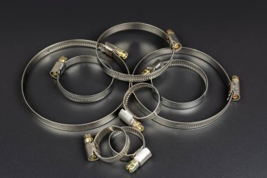 Hortum bağlantısı için çeşitli metal kıskaçlar siyah arkaplanda izole edildi