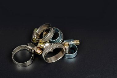 Hortum bağlantısı için çeşitli metal kıskaçlar siyah arkaplanda izole edildi