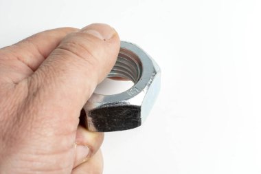 Bir adam elinde büyük metal bir fındık tutar.