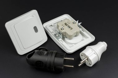 Siyah arkaplanda elektrik prizleri, prizler ve ışık düğmesi yakın plan